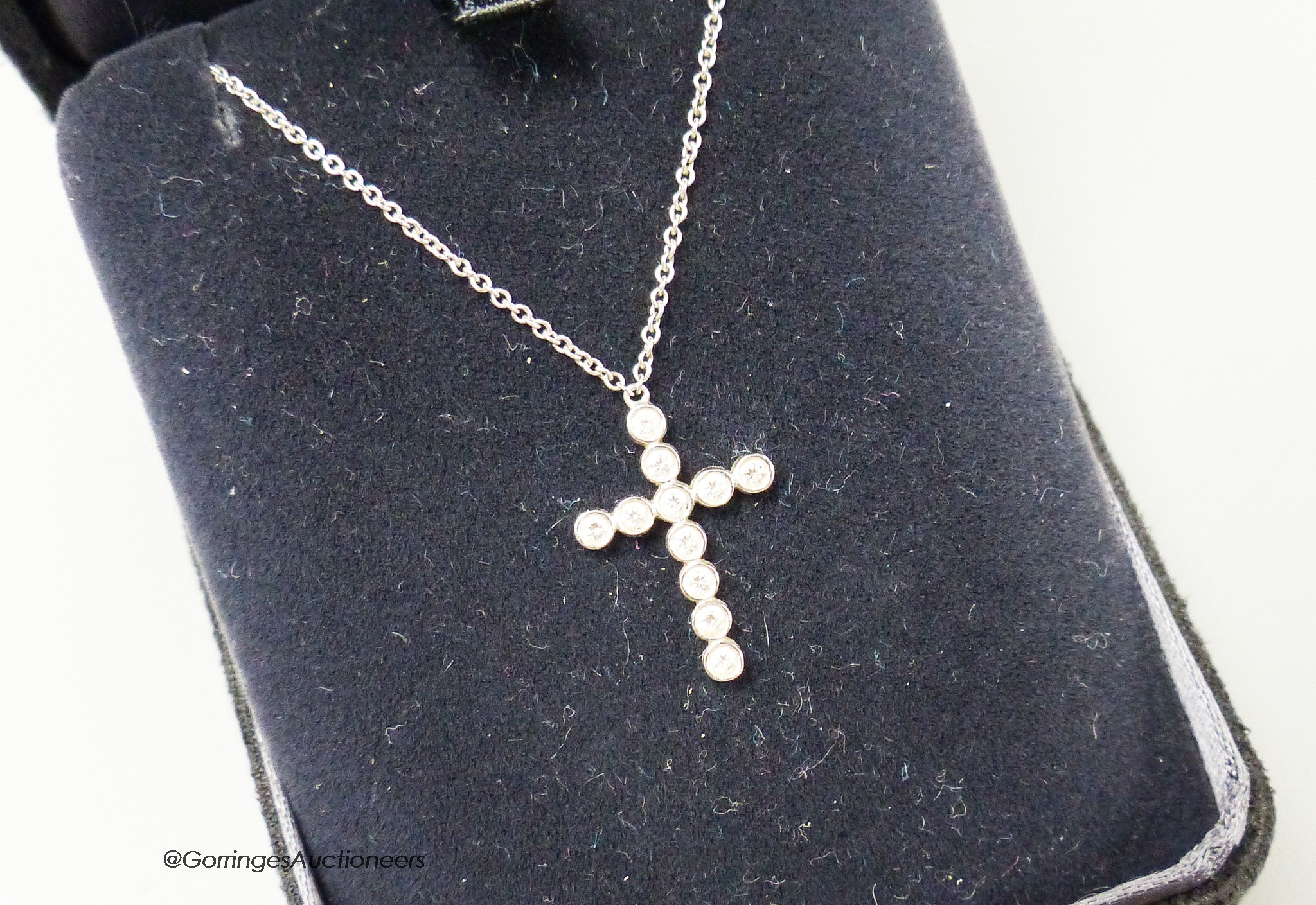 A modern Tiffany & Co platinum and diamond set cross pendant necklace, pendant 18mm, chain 40cm, gross weight 3 grams, with Tiffany box.
